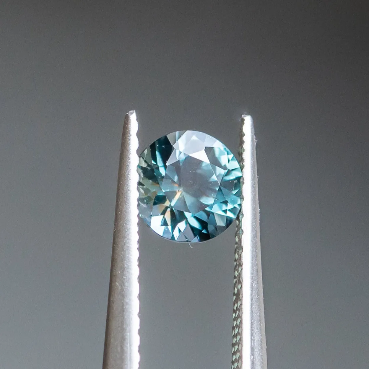 0.83CT ROUND BRILLIANT SONGEA SAPPHIRE, DENIM BLUE WITH BRIGHT TEAL FLASHES, 5.60X3.70MM