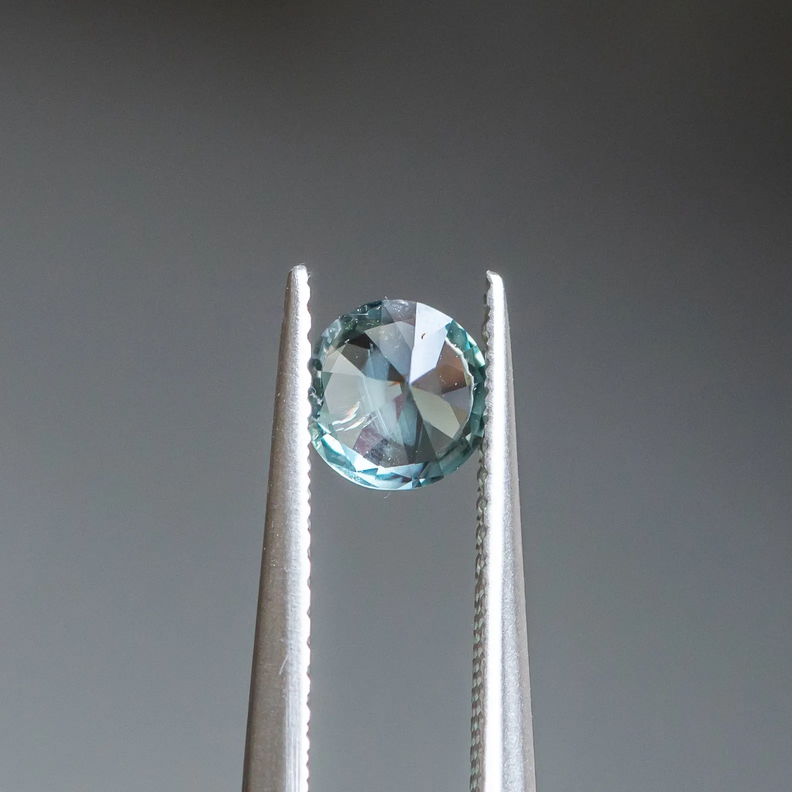 0.83CT ROUND BRILLIANT SONGEA SAPPHIRE, DENIM BLUE WITH BRIGHT TEAL FLASHES, 5.60X3.70MM